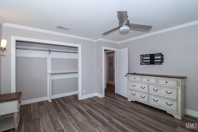 unfurnished bedroom with dark wood-type flooring, a closet, crown molding, and ceiling fan