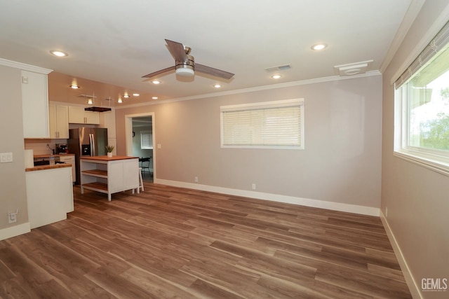 kitchen with white cabinets, dark hardwood / wood-style floors, and ornamental molding