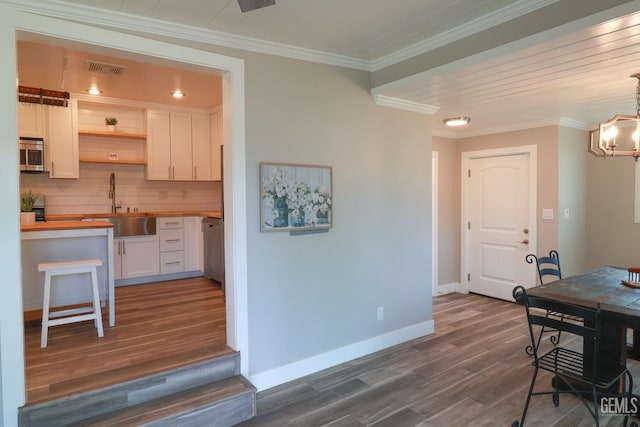 kitchen with sink, hanging light fixtures, dark hardwood / wood-style floors, decorative backsplash, and white cabinets