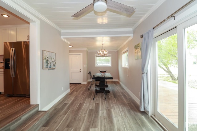 dining space with wood-type flooring, ceiling fan with notable chandelier, and ornamental molding