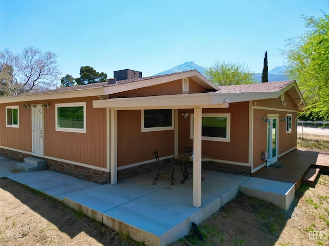 rear view of property featuring a mountain view, central AC, and a patio area