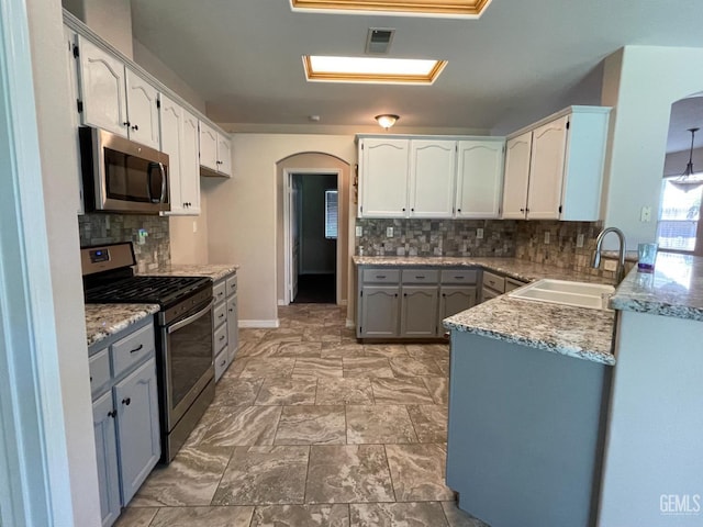 12007 Roaring River Ave, Bakersfield, CA 93311 - kitchen with appliances with stainless steel finishes, a sink, arched walkways, and tasteful backsplash