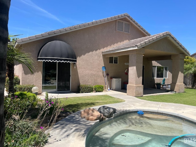 12007 Roaring River Ave, Bakersfield, CA 93311 - back of house with stucco siding, a patio, a hot tub, and a tile roof