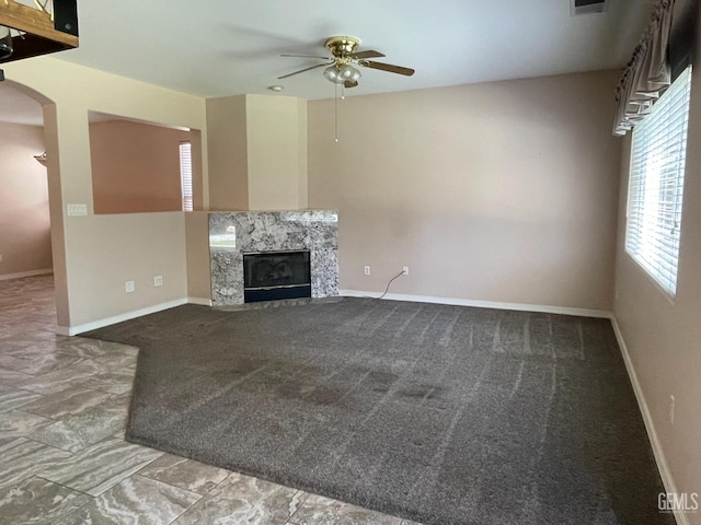 12007 Roaring River Ave, Bakersfield, CA 93311 - unfurnished living room featuring ceiling fan, a high end fireplace, carpet floors, and baseboards
