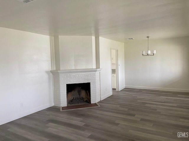 115 Olive St, Bakersfield, CA 93304 - unfurnished living room with dark wood-style flooring, visible vents, baseboards, and a brick fireplace