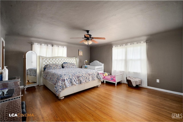 13271 Garzoli Ave, Mc Farland, CA 93250 - bedroom featuring multiple windows, wood finished floors, a ceiling fan, and baseboards