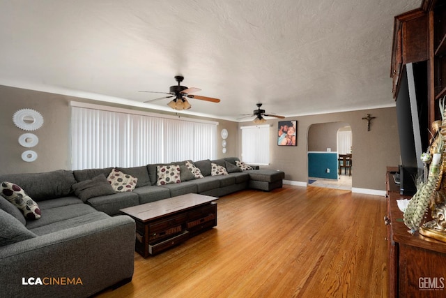 13271 Garzoli Ave, Mc Farland, CA 93250 - living area with arched walkways, a ceiling fan, light wood-type flooring, and baseboards