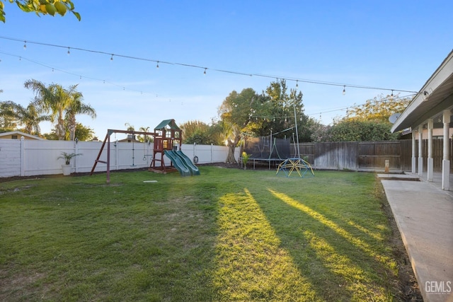 view of yard with a playground and a trampoline