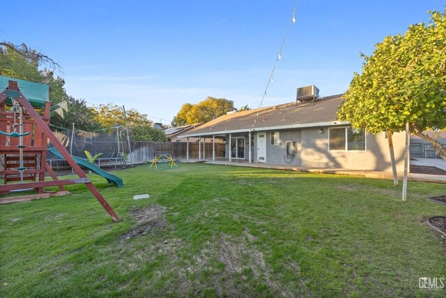 exterior space featuring a patio, a trampoline, a playground, and central AC