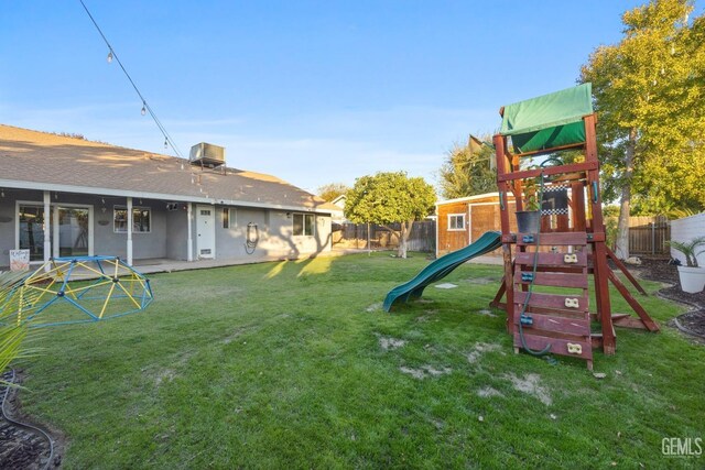 view of jungle gym featuring central AC unit and a yard