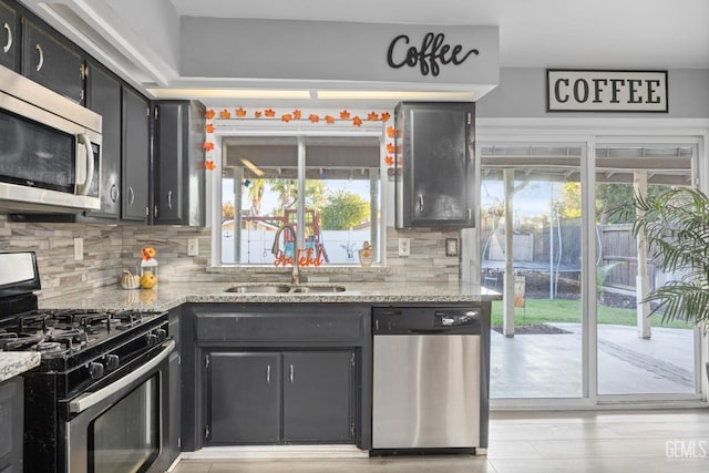 kitchen with a healthy amount of sunlight, sink, appliances with stainless steel finishes, and tasteful backsplash