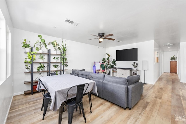 dining area featuring light wood finished floors, visible vents, baseboards, and a ceiling fan