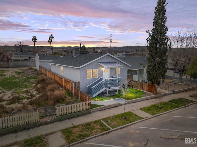 view of front of house with stucco siding and a fenced front yard