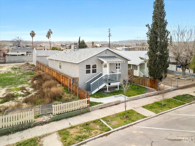 view of front of home featuring stucco siding and a fenced front yard