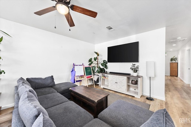 living room featuring visible vents, baseboards, light wood-type flooring, and a ceiling fan
