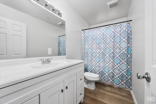 bathroom featuring toilet, wood finished floors, vanity, and visible vents
