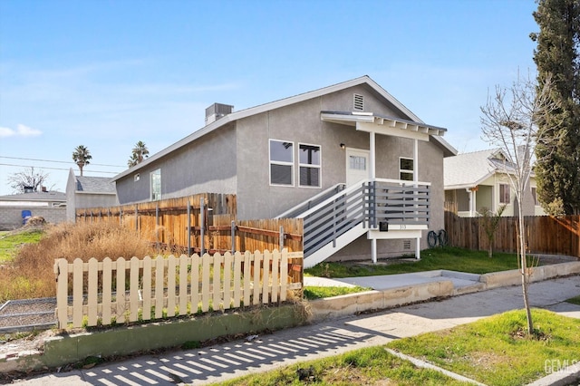 bungalow with fence and stucco siding