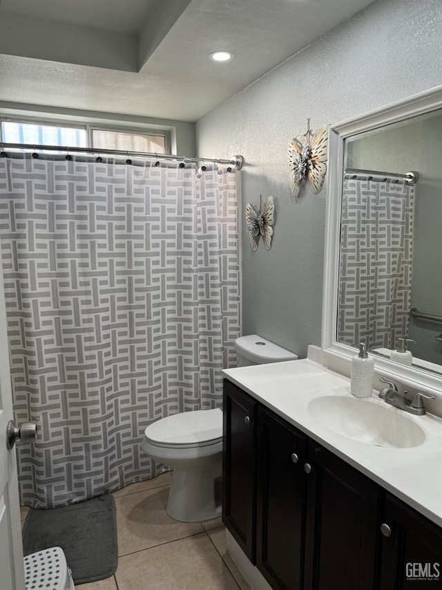 bathroom featuring toilet, a shower with shower curtain, tile patterned flooring, and vanity