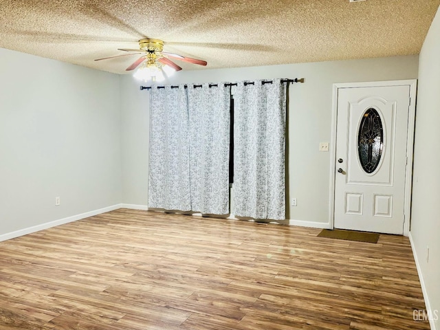 entrance foyer featuring baseboards, a textured ceiling, wood finished floors, and a ceiling fan
