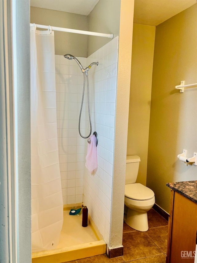 full bathroom featuring tile patterned floors, toilet, a stall shower, and vanity