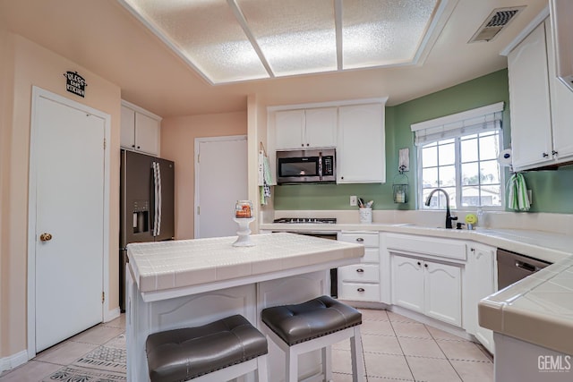 kitchen with sink, white cabinets, and appliances with stainless steel finishes