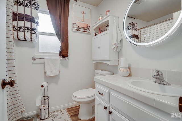 bathroom with vanity, hardwood / wood-style floors, and toilet