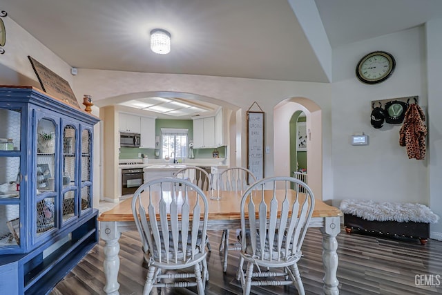 dining space with dark hardwood / wood-style floors and sink