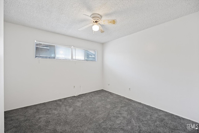 empty room with a textured ceiling, dark carpet, and ceiling fan