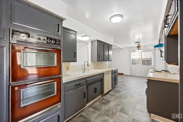 kitchen featuring white dishwasher, sink, black double oven, ceiling fan, and decorative backsplash