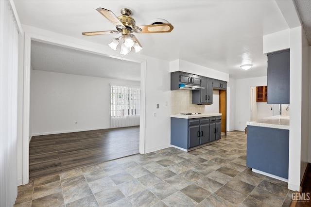 kitchen featuring stovetop, decorative backsplash, and ceiling fan