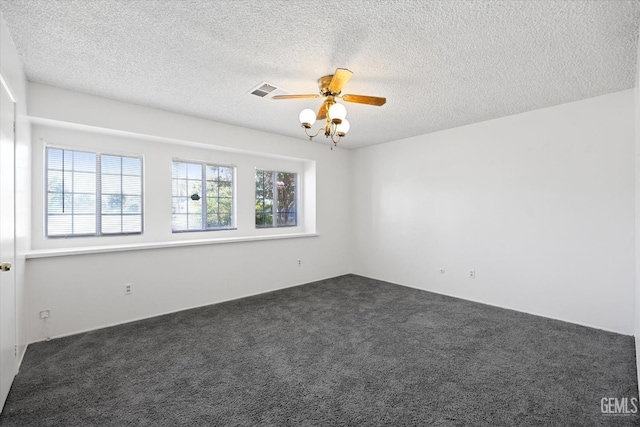 empty room with dark colored carpet, a textured ceiling, and ceiling fan