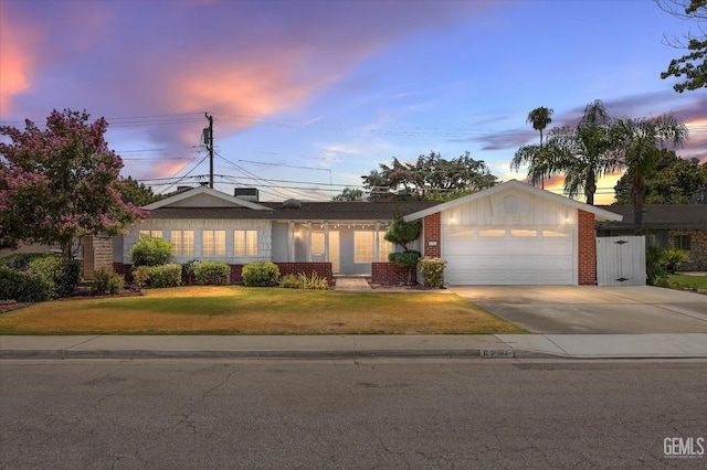 ranch-style house with solar panels, a yard, and a garage