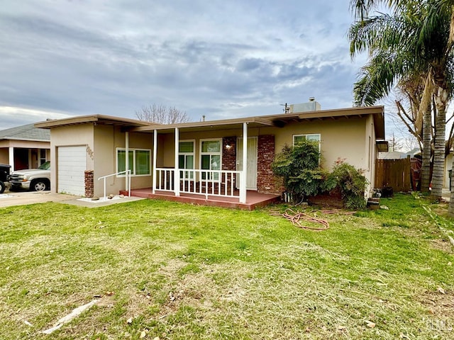 ranch-style home featuring a front yard, an attached garage, covered porch, and stucco siding