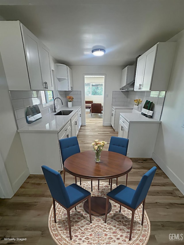 3417 River Blvd, Bakersfield, CA 93305 - kitchen featuring ventilation hood, light countertops, tasteful backsplash, and light wood-style floors