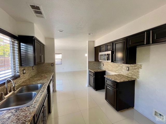 kitchen with stainless steel microwave, plenty of natural light, visible vents, and a sink