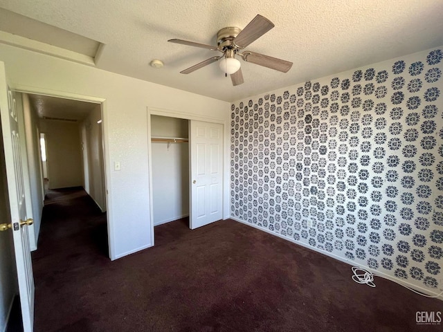 unfurnished bedroom with a ceiling fan, carpet, a closet, and a textured ceiling