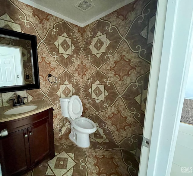 bathroom with tile patterned floors, visible vents, toilet, and vanity