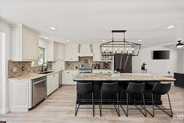 7544 Clifford Ct, Bakersfield, CA 93313 - kitchen featuring stainless steel appliances, custom exhaust hood, a sink, a breakfast bar area, and recessed lighting