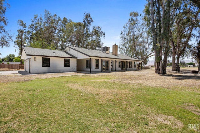 7544 Clifford Ct, Bakersfield, CA 93313 - rear view of property featuring a chimney, an attached garage, a lawn, driveway, and a patio area