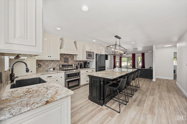 7544 Clifford Ct, Bakersfield, CA 93313 - kitchen with a sink, stainless steel appliances, custom exhaust hood, a kitchen bar, and decorative backsplash