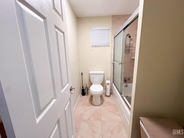 bathroom featuring toilet and shower / bath combination with glass door