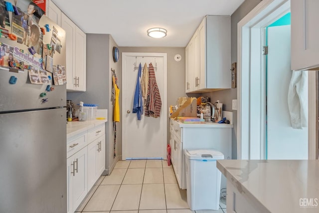 7958 Harmony Ln, Onyx, CA 93255 - kitchen featuring freestanding refrigerator, light countertops, light tile patterned floors, and white cabinets
