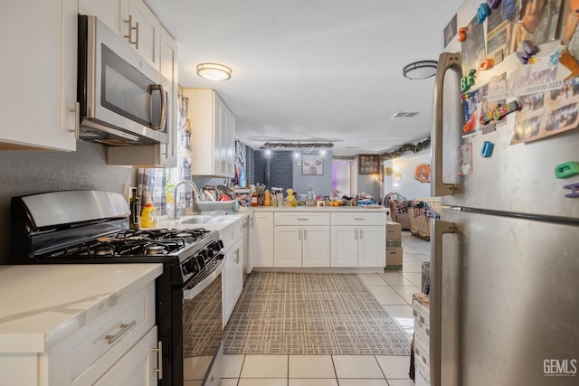 7958 Harmony Ln, Onyx, CA 93255 - kitchen with appliances with stainless steel finishes, light tile patterned floors, a peninsula, and white cabinetry