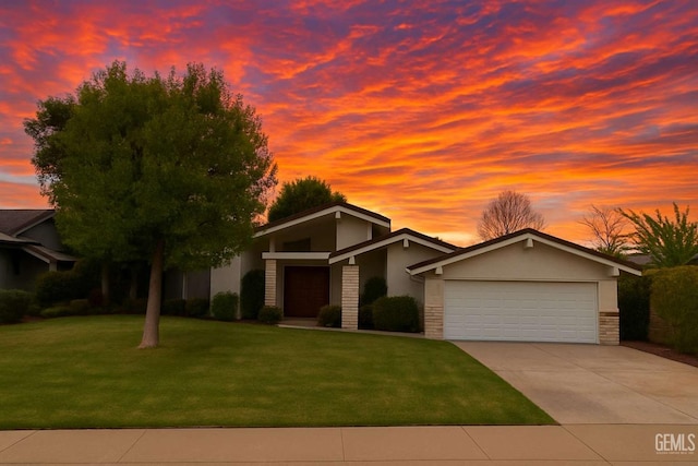 mid-century home with an attached garage, stone siding, stucco siding, concrete driveway, and a lawn