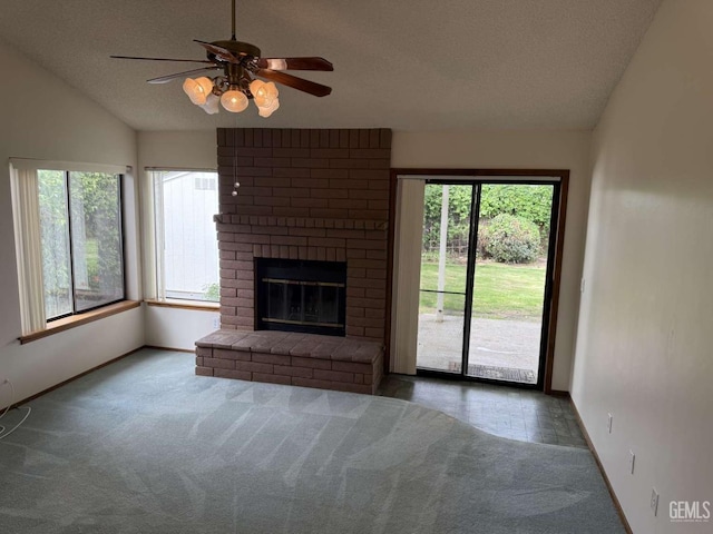 unfurnished living room featuring baseboards, plenty of natural light, vaulted ceiling, and a textured ceiling