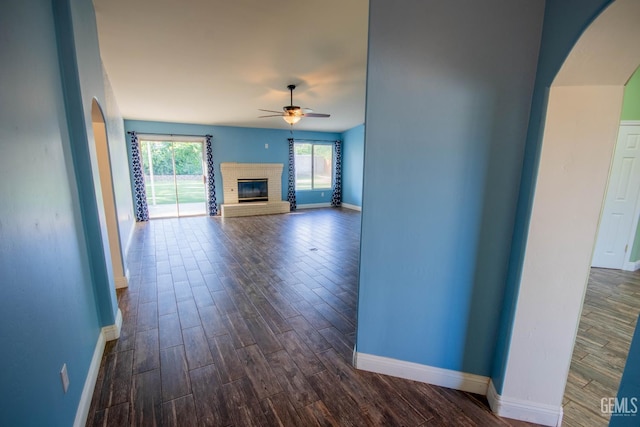 5514 Lombardy Ct, Bakersfield, CA 93308 - unfurnished living room with a ceiling fan, baseboards, arched walkways, and dark wood-style flooring