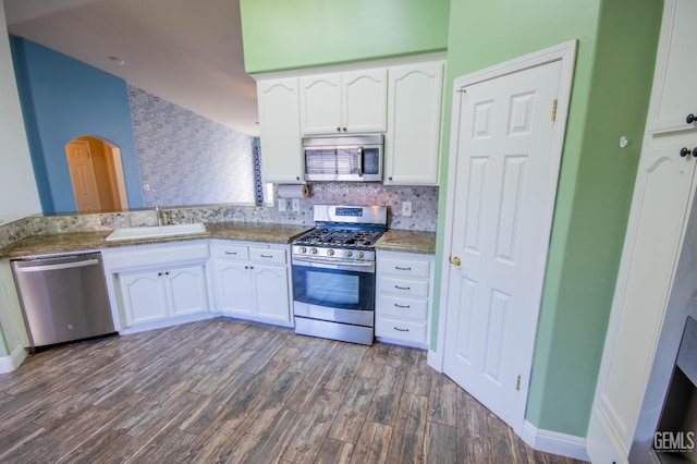 5514 Lombardy Ct, Bakersfield, CA 93308 - kitchen with stainless steel appliances, a sink, white cabinetry, dark wood-style flooring, and arched walkways