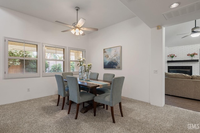 dining space with a ceiling fan, visible vents, light carpet, and a wealth of natural light