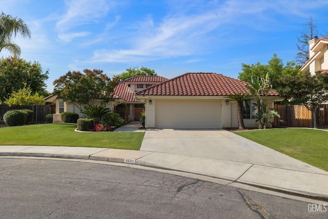 mediterranean / spanish-style house with a tiled roof, a garage, fence, a front lawn, and concrete driveway
