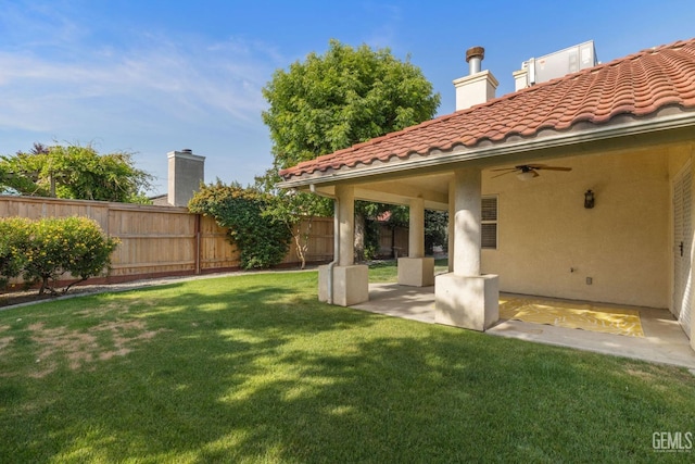 view of yard with fence, a patio, and ceiling fan